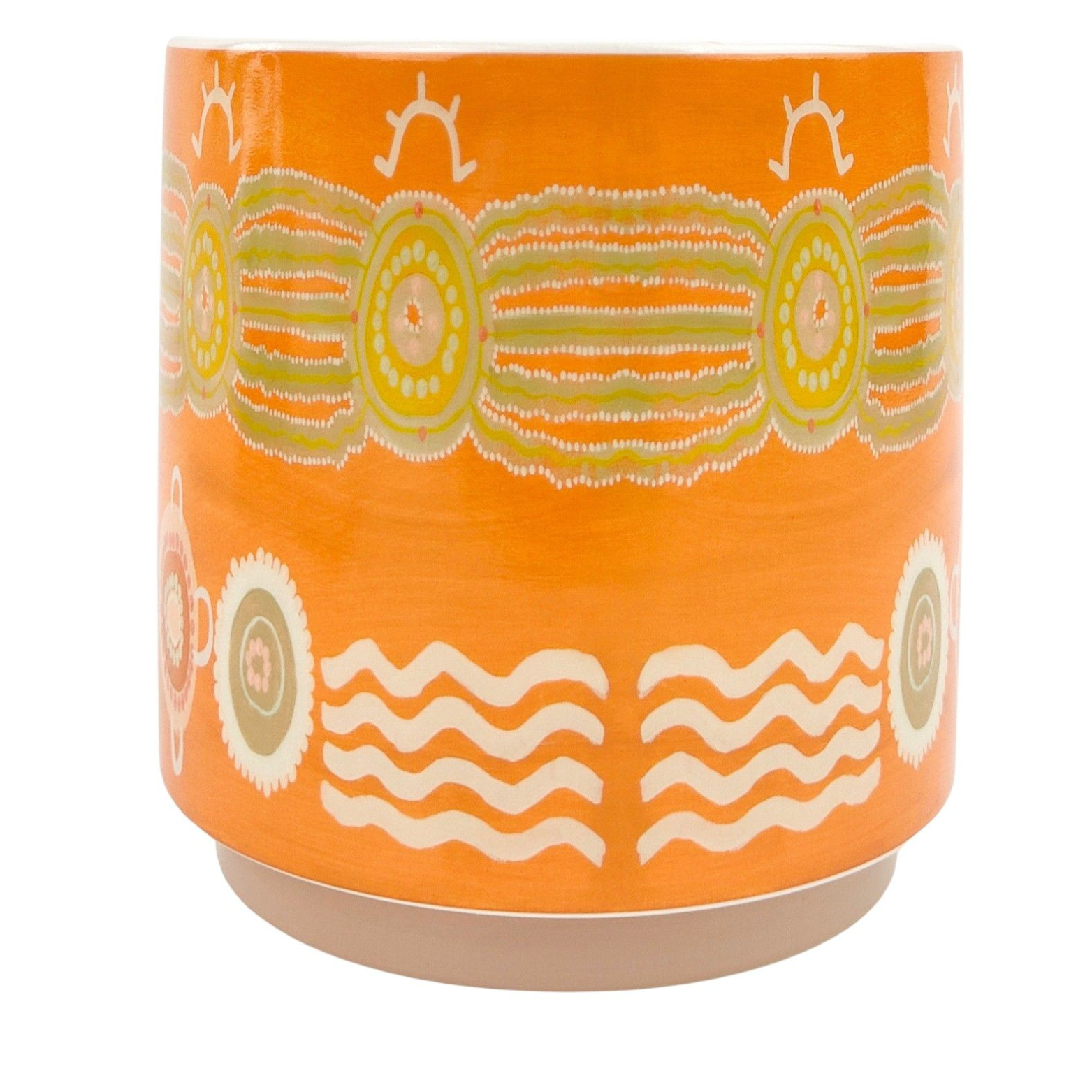Orange ceramic pot with decorative patterns on a white background