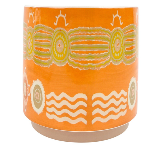 Orange ceramic pot with decorative patterns on a white background