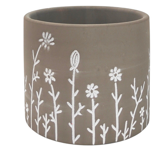 Ceramic planter with white floral design on a brown background